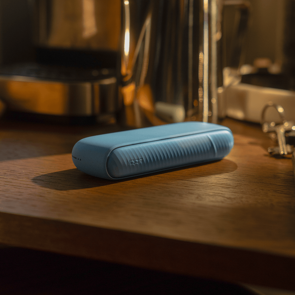 An IQOS ILUMA pocket charger laying on a table
