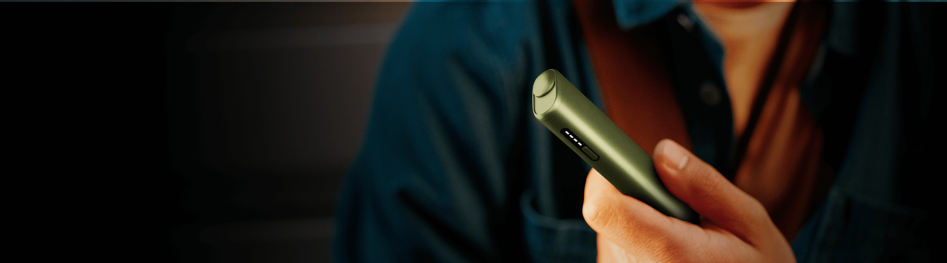 A man holding an IQOS iluma i ONE