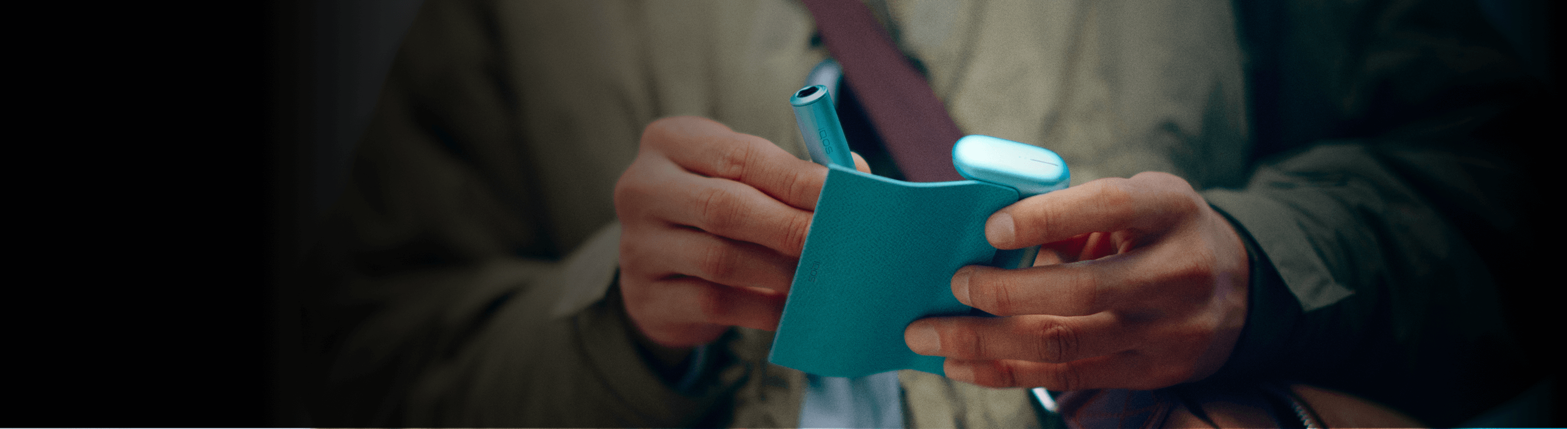 A man holding an IQOS iluma i prime