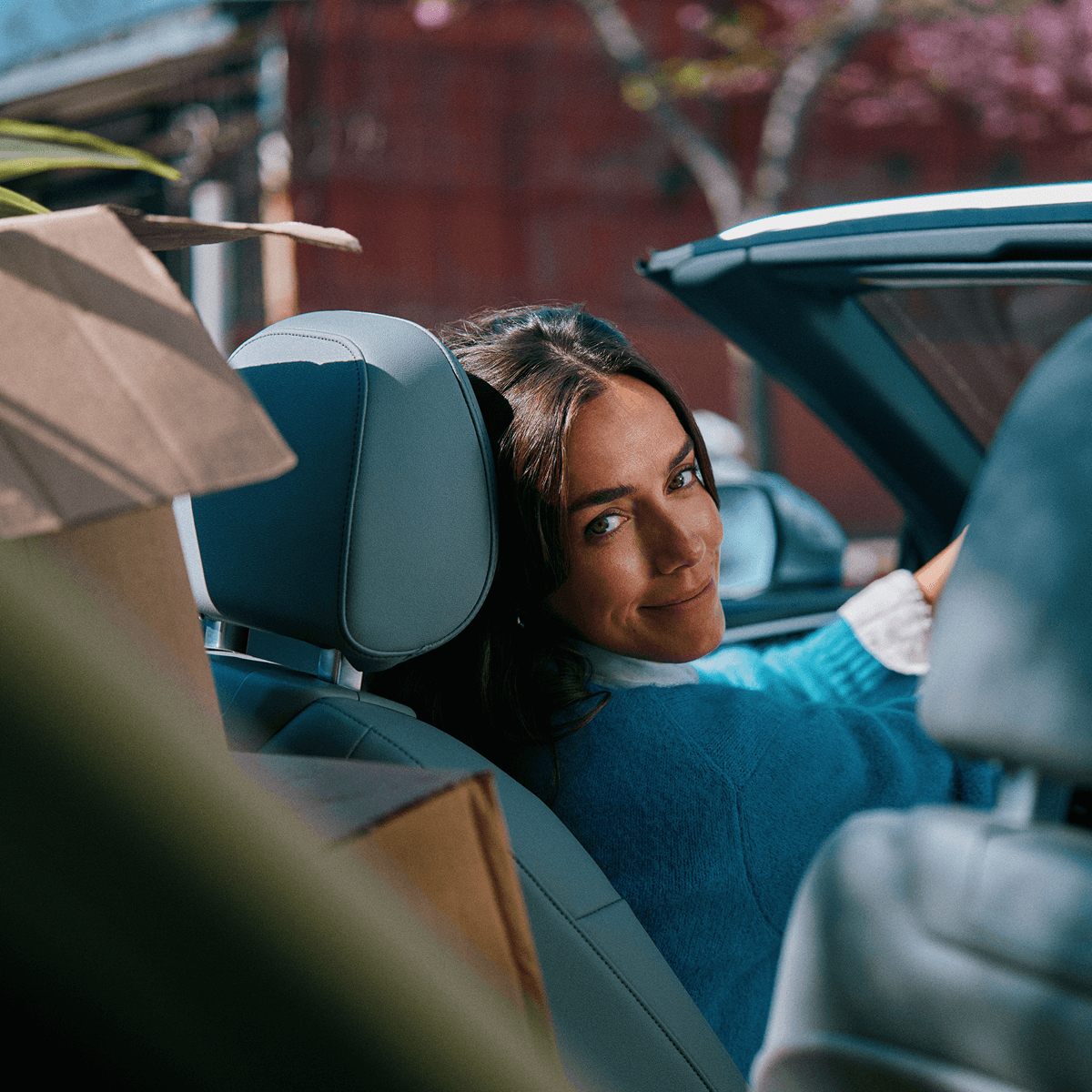 En kvinde i sin bil, der kigger over skulderen