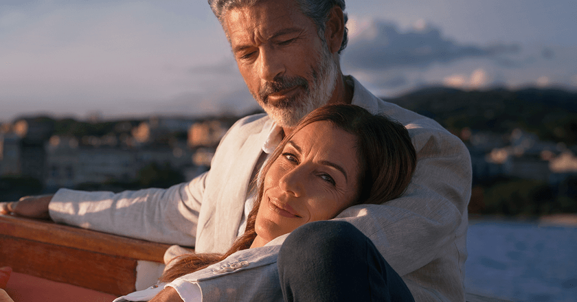 En kvinde, der læner sig op ad en mand på en båd